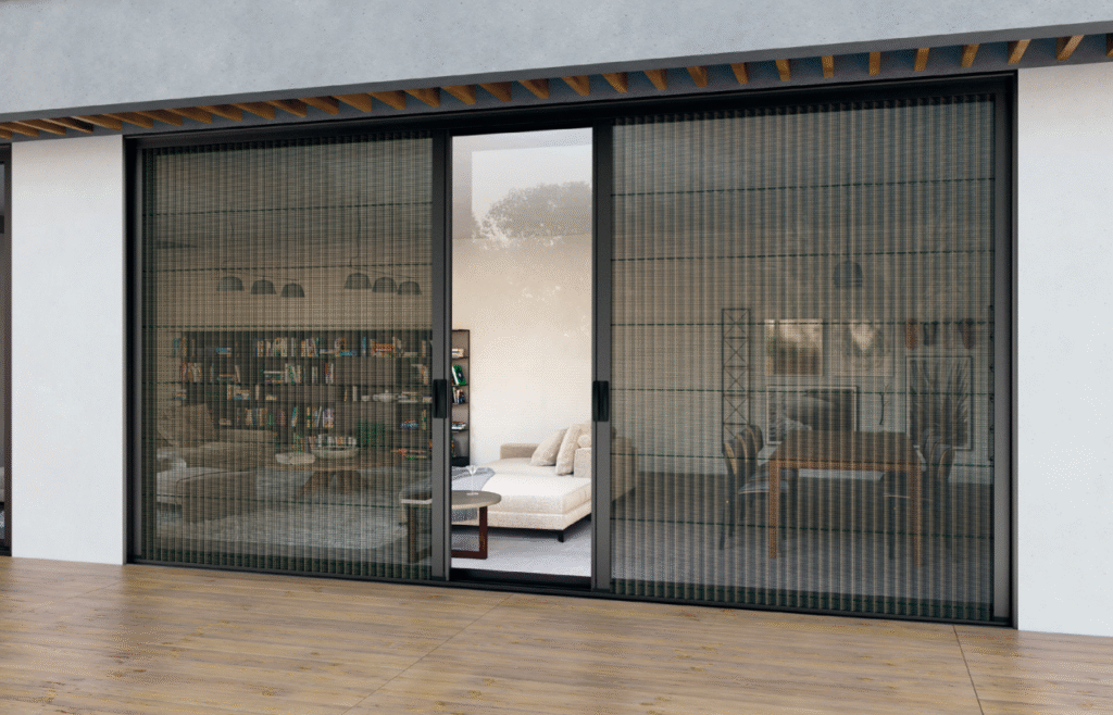 Bursa'da bir verandaya açılan geniş sürgülü kapı için monte edilmiş, siyah renkli, raylı sürme sineklik sistemi.