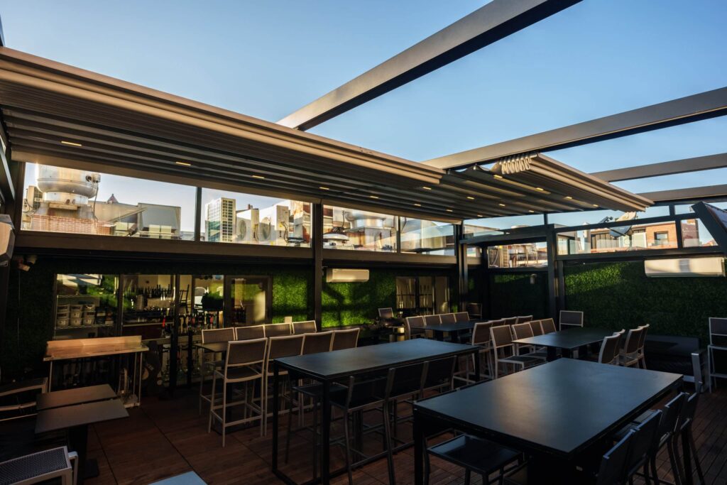 Bursa'da bir kafe terasında uygulanan, modern motorlu açılır tavan (pergola) ve etrafı camla kaplanmış oturma alanı.